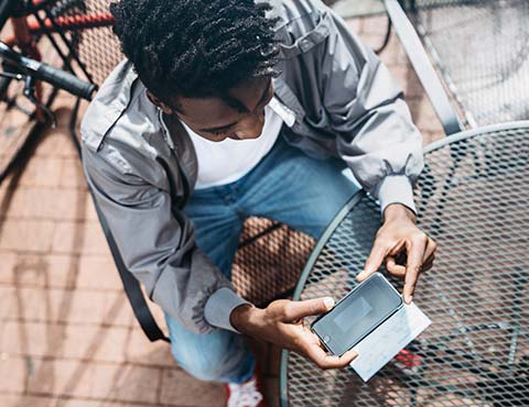 Young man taking photo of check with phone.